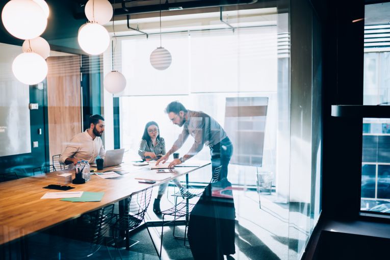 three people in an office meeting